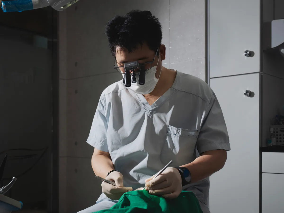 Dr. Chulmin Bae performing surgery with magnification loupes at Oaks Dental Clinic