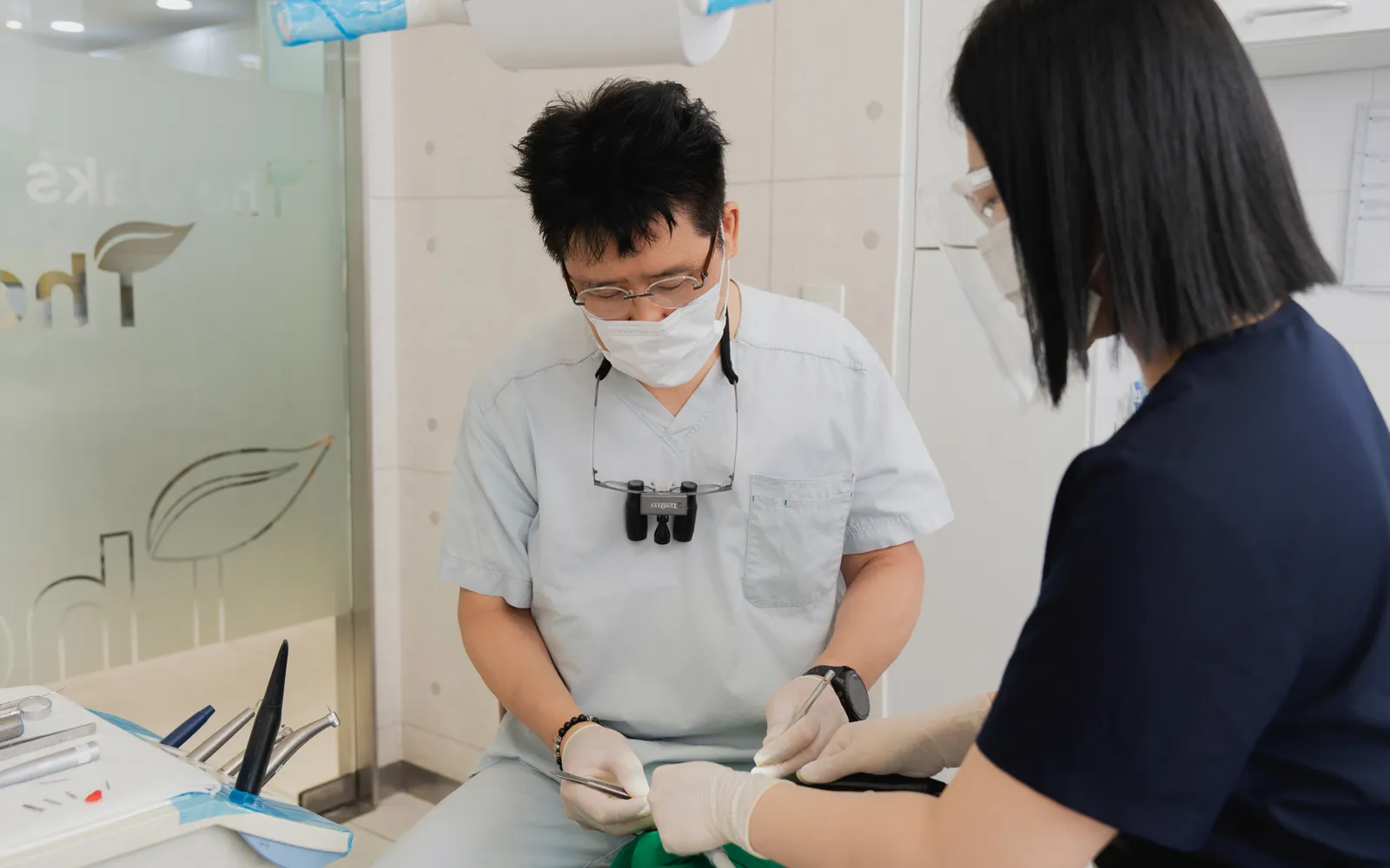 Dr. Chulmin Bae and an assistant treating a patient at Oaks Dental Clinic
